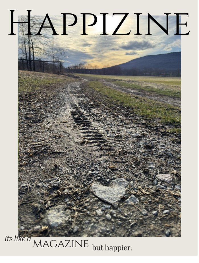 Happizine cover featuring a heart-shaped stone in tire tracks at sunset